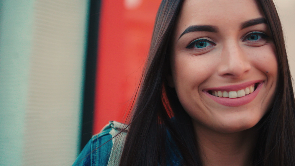 Professional Dental Care Results in Scotts Valley Close up beautiful woman face portrait. Young attractive woman looking at the camera and smiling on the city street