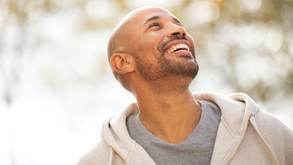 Professional Dental Care Results in Scotts Valley Close up portrait of a smiling man looking up towards the sky with a hopeful expression.