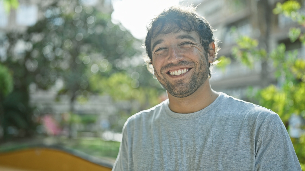Professional Dental Care Results in Scotts Valley Handsome young blond man standing confident and smiling in the city park, appearing joyful and positive. closeup portrait showcasing his cheerful expression and laugh.