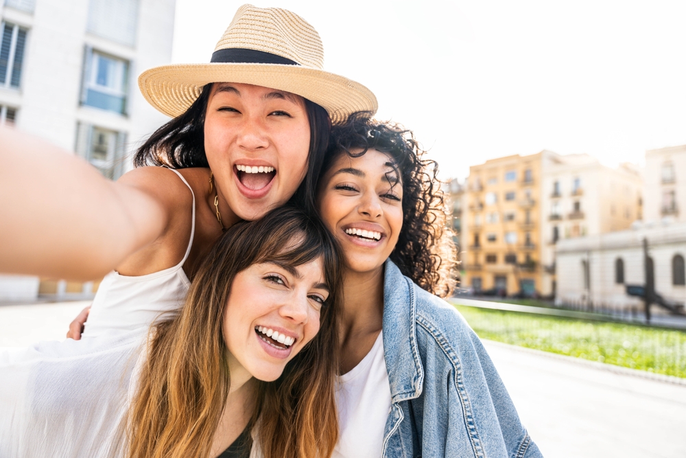Professional Dental Care Results in Scotts Valley Multiracial three young women taking selfie portrait on city street - Happy female friends having fun together hanging outside - Life style concept with beautiful girls enjoying summer holidays