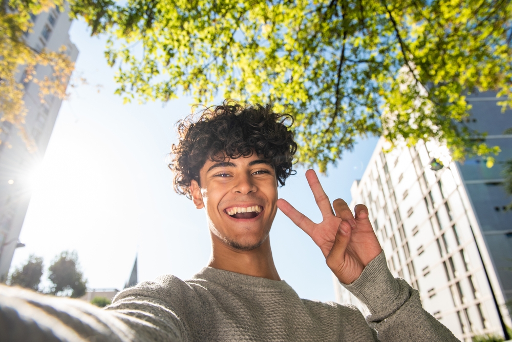 Portrait handsome young man taking selfie with hand peace sign