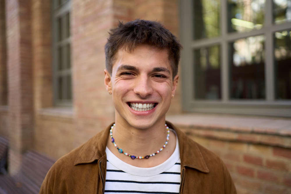 Scotts Valley Dental Patient Portrait of happy handsome Caucasian man with big smile posing looking at camera on university campus. Young student guy with cheerful and positive attitude outdoor. Generation z people photo