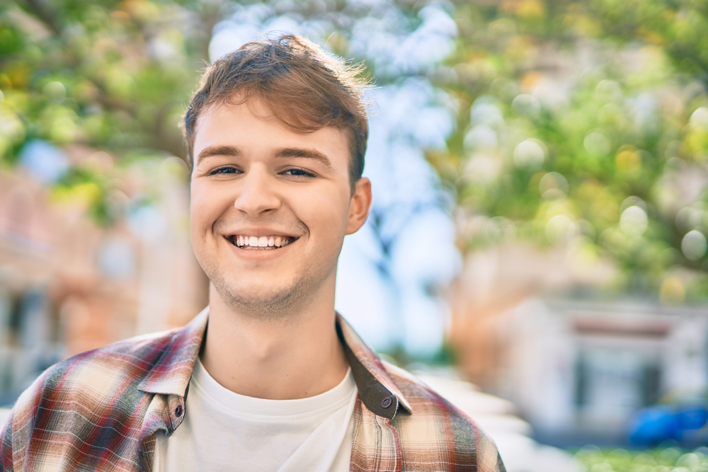 Young caucasian man smiling happy standing at the city.