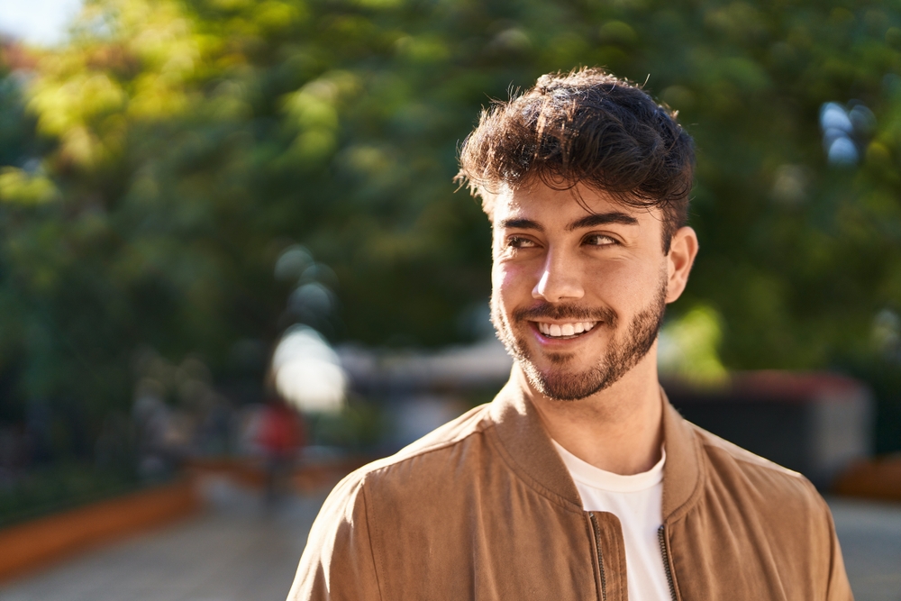 Custom dental implant restorations in Scotts Valley, CA Smiling man outdoors representing restored function and confidence with a custom dental implant restoration