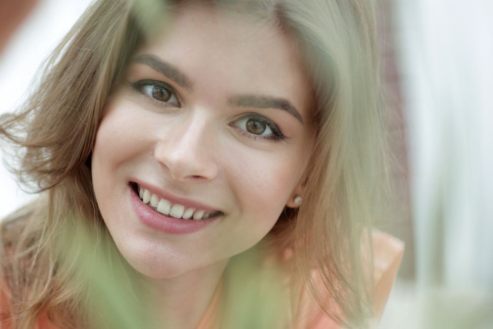Confident Smiles from Dental Care in Scotts Valley portrait of smiling woman face on blurred background.
